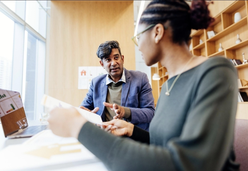 Real estate broker and client reviewing a property management proposal